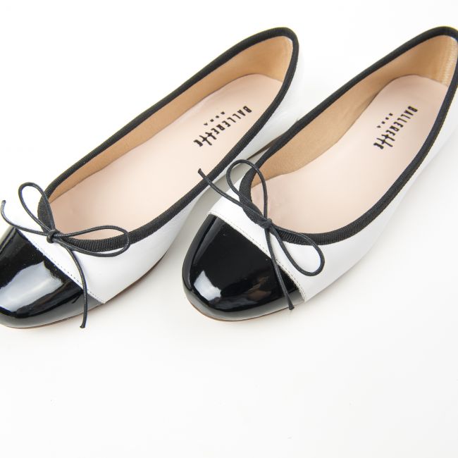 White leather ballet flats and black patent toe